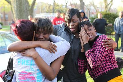 Shakeitha Myers, second from left, Pamela Jackson and Delores Ousley, right, cry early Wednesday, April 14, 2010 outside the crime scene at a Marquette neighborhood residence on the southwest side of Chicago. A gunman entered a home early Wednesday, fatally shooting four people, three of them children, and wounding two others, city police said. (AP Photo/Chicago Tribune, Alex Garcia) 